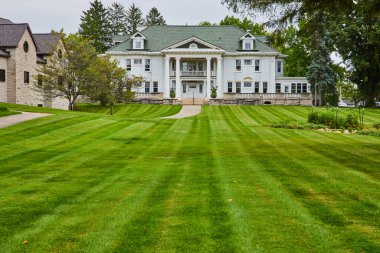 Yeşil çimenli ve küçük sebze bahçeli büyük bir emlak evi resmi, Muncie Indiana