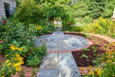 Minnetrista Müzesi ve Bahçeler yolu sarı papatya çiçekleri ve yarı ölü ve canlı bitkilerle çevrili.