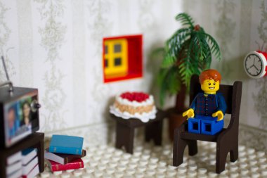 LEGO oyuncak figürü ev ortamında rahat bir hayat yaşıyor, etrafında eğlence ve eğlence seçenekleri var. Baştan çıkarıcı bir pastayla bir kutlama anı. Rahatlama temaları için mükemmel