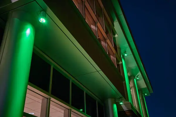 Captivating modern building lit with vibrant green lights at night, showcasing contemporary architecture and sustainable design in Fort Wayne, Indiana.
