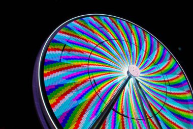 Geceleri büyüleyici dönme dolap Gatlinburg, Tennessee 'deki bir eğlence parkının canlı ruhunu aydınlatır. Renkli ışıklar ve hareket bulanıklığı dolu canlı bir görüntü yaratır..