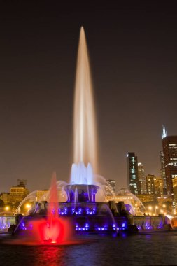 Chicago, Illinois 'in ışıl ışıl şehir manzarası aydınlanmış binaların zeminine karşı görkemli aydınlatılmış bir çeşme sergiliyor ve gece kentsel yaşamın güzelliğini yansıtıyor..