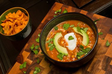 Ekşi krema, avokado dilimleri ve kişniş ile süslenmiş nefis ev yapımı tavuk enchilada çorbası. Mutfak temaları ve doyurucu yemekler için mükemmel. Konum: Fort Wayne