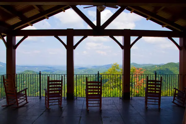 Escape to Serenity: A rustic pavilion in Gatlinburg, Tennessee offers a breathtaking mountain view, inviting you to unwind in wooden rocking chairs and immerse yourself in the beauty of nature