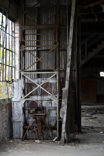 Decaying Industrial Relic: Once bustling with activity, this abandoned warehouse in Warsaw, Indiana now stands forgotten. A rusted lift mechanism, weathered metal doors, and broken windows tell a tale