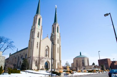 Fort Wayne, Indiana şehir merkezindeki tarihi katedralin görkemli güzelliğini keşfedin gotik kuleler ve karmaşık mimari detaylarla süslenmiştir. Etrafı kar bulutlarıyla çevrili, bu kadar huzurlu.