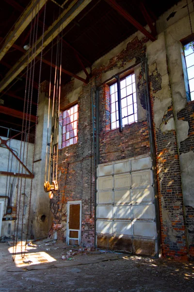 インディアナ州オーバーンで放棄された工業倉庫 都市の衰退とタイムズ パッセージの遺言 ガレージドアとハンドチェーンホイスト付きローディングベイ — ストック写真