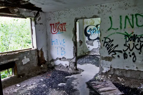 Captivating urban decay: Abandoned TB hospital in Lima, Ohio showcases a derelict interior with peeling paint, scattered debris, and vibrant graffiti tags. Explore the passage of time and the impact