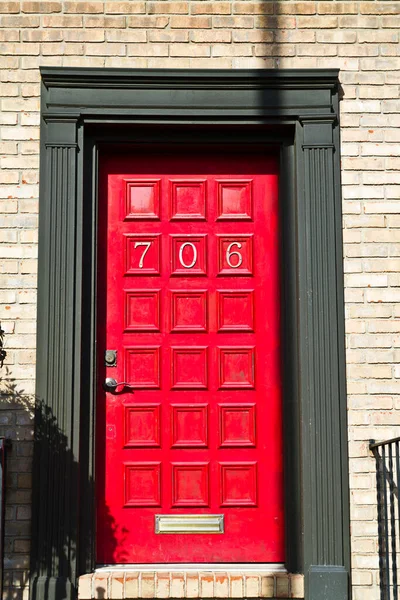 House Number 706 on Vibrant Red Door with an Urban Brick Wall Facade - A Welcoming Entryway in Evansville, Indiana