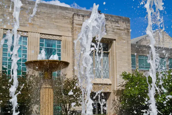 インディアナ州ブルーミントンにある古典的な建築の詳細を備えたエレガントな建物の中で 水噴水を魅了します 時間内に凍結され 水のダイナミックなスプレーは 爽快な光景を作成し — ストック写真