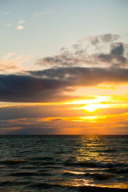 Michigan Gölü üzerinde büyüleyici bir gün batımı, ılık altın renkleri, zıt bulutları ve dalgalanan dalgalarla sakin bir deniz manzarası. Seyahat, eğlence ve sağlık konuları için mükemmel..