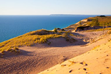 Michigans 'taki sakin sahil kumulları nefes kesen altın kumlar, canlı mavi sular ve el değmemiş doğal güzellik manzarası sunuyor..