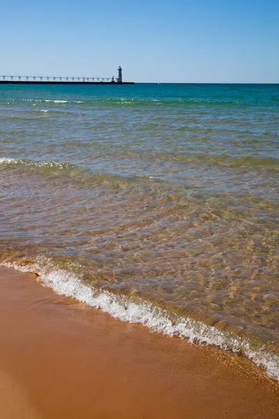 Spokojna Scena Plaży Majestatyczną Latarnią Morską Końcu Molo Otoczona Czystymi — Zdjęcie stockowe