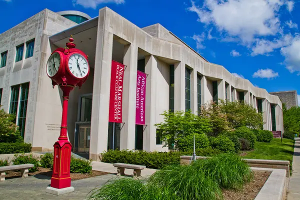 在印第安纳彭明顿一个充满活力的大学校园里 永恒的优雅 这个迷人的红钟高高地矗立在原始的蓝天下 而一个容纳尼尔 马歇尔非洲人的现代建筑却屹立在那里 — 图库照片