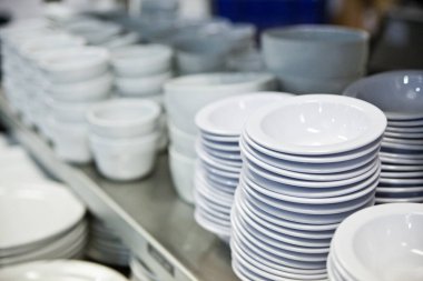 Ticari bir mutfakta güzelce istiflenmiş seramik tabaklar, Auburn, Indiana 'da temiz ve düzenli restoran ürünleri sergileniyor..