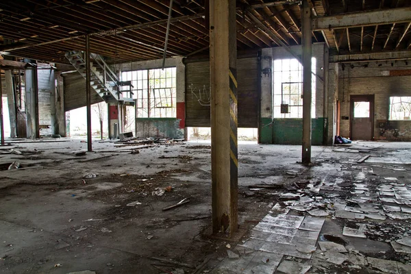 Abandoned Industrial Building in Warsaw, Indiana: A haunting scene of urban decay with peeling paint, scattered debris, and eerie lighting, showcasing the decline of a once-thriving factory.