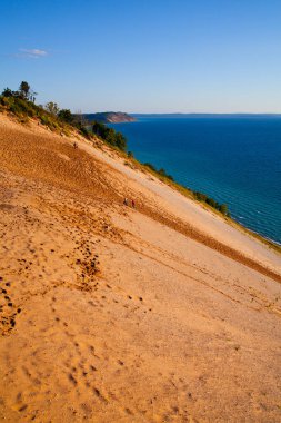 Michigans Empire State Parkı 'nın çarpıcı kumlu yamaçlarını ve el değmemiş mavi sularını keşfedin. Maceranın ve doğal güzelliğin özünü yakalayın..