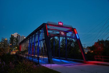 Fort Wayne, Indiana 'da, Wells Caddesi Köprüsü' nde alacakaranlık parlıyor. Şehir siluetine karşı ışıltılı tasarımı gözler önüne seriliyor..