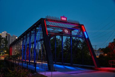Canlı çelik kiriş köprüsü Fort Wayne, Indiana 'da alacakaranlık gökyüzüne karşı renkli ışıklarla yıkandı..