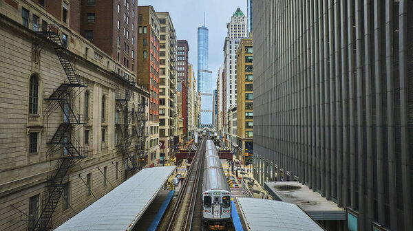 Image of Train travel and tourism between downtown skyscraper buildings toward Trump Tower, aerial Chicago