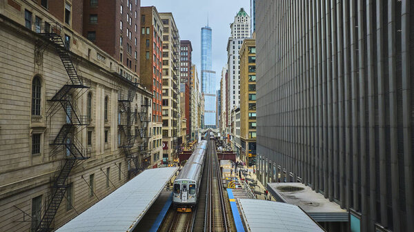 Image of Train traveling toward Trump Tower, tourism with downtown skyscraper buildings, Chicago aerial