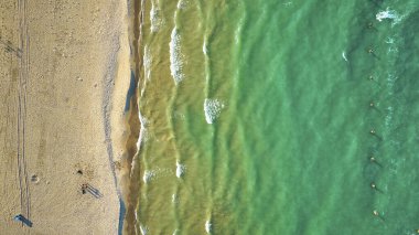 Güneşli dalgalar ve su, turizm, turizm ve seyahatlerden oluşan kumlu sahil boyunca yeşil su görüntüsü