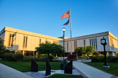 Delaware Adliyesi, Indiana 'da altın saat gündoğumu. Önde gelen Amerikan bayrağı, modern mimarisi ve huzurlu bahçesiyle vatanseverlik sergiliyor..
