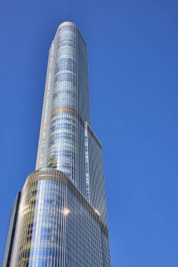 Trump Tower 'ın açık mavi gökyüzü ile aydınlık yaz günündeki görüntüsü mimari ve çevresindeki Chicago Illinois