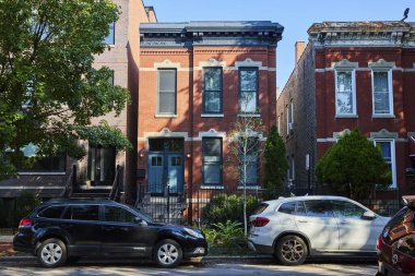 Güneşli bir günde ön tarafa park edilmiş siyah beyaz arabalı Brick evleri, şehrin iç kısımları, ipotek