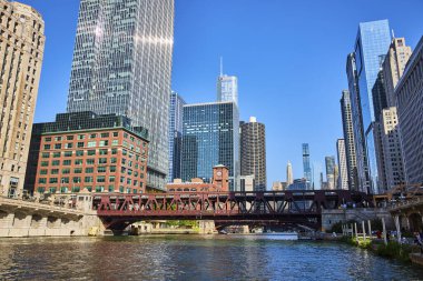 Güneşli bir yaz gününde, mavi gökdelenler altında kırmızı köprüler ve şehir gökdelenleri olan Kanal 'ın resmi, Chicago Illinois ABD