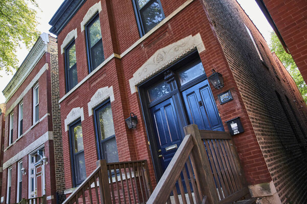 Image of Tilted view of old red brick house with black doors, ominous, haunted, evil, finance, mortgage