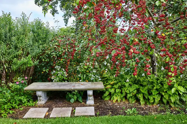 Serene Botanic Garden Scene in Elkhart, Indiana, 2023 - Stone Bench, Vibrant Greenery, and Colorful Blossoms
