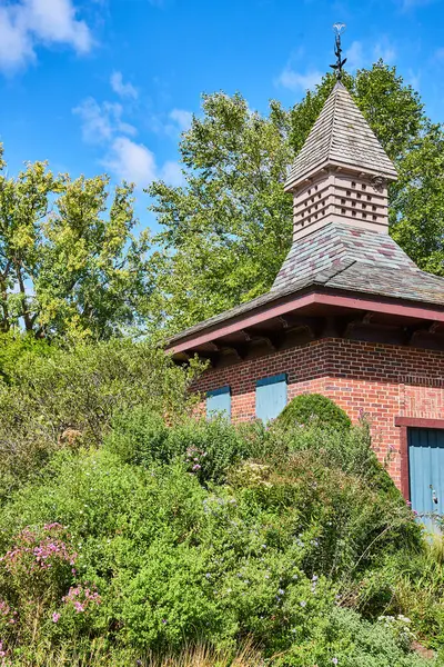 Quaint Brick Structure Whimsical Weathervane Amidst Lush Foliage Botanic Gardens — Stock Photo, Image