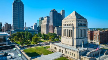 Indianapolis 'teki Indiana Savaşı Anıtı' nın gündüz hava görüntüsü, açık mavi gökyüzü altındaki neoklasik ve modern mimariye zıt.