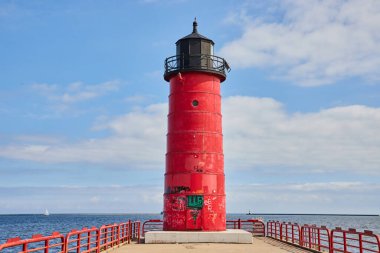 Milwaukee, Wisconsin 'deki canlı kırmızı deniz feneri, 2023' te mavi gökyüzü arkaplanına karşı tarih ve ihmalkârlık belirtileri gösteriyor..