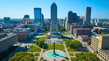 Indianapolis 'in tarihi Indiana Savaşı Anıtı, Obelisk Meydanı ve açık mavi gökyüzü altındaki modern şehir manzarasını gösteren hava manzarası.