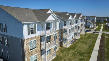 Fort Wayne, Indiana 'daki simetrik apartmanın güneşli hava manzarası modern mimari, düzgünce döşenmiş çimenler ve sakin banliyölerde yaşayan