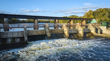 Ann Arbor, Michigan 'daki Huron Nehri' nde Argo Barajı 'nı aydınlatan altın öğlen güneşi bir DJI Mavic 3 insansız hava aracı tarafından yakalandı. Enerji ve altyapı, doğanın güzelliğiyle buluşur..