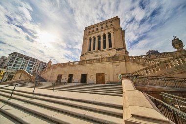 Indianapolis, Indiana şehir merkezindeki neoklasik bina, parçalı bulutlu bir gökyüzünün altında, modern bir daire ile çelişiyor, 2023