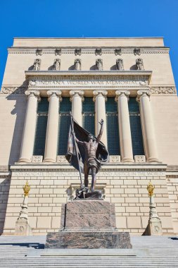 Indianapolis, Indiana Dünya Savaşı Anıtı 'ndaki bronz asker heykeli, açık mavi gökyüzünün altında, vatanseverlik duygusunu ve tarihsel anısını simgeliyor, 2023.