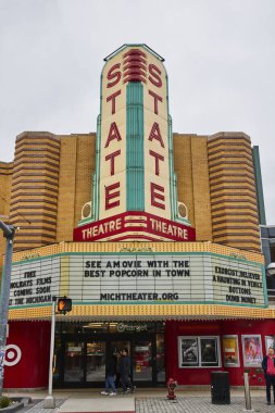 Şehir merkezindeki Ann Arbor, Michigan 'daki Şehir Caddesindeki klasik devlet tiyatrosu afişi, Yeni Gelen Film Listeleri ile Pedestrianları davet ediyor.