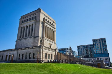 Indianapolis, Indiana 'da Yüksek Sütunlar ve Heykellerle Klasik Hükümet Binası, Modern Apartman Kompleksi ile çelişiyor, Açık Mavi Gökyüzü altında 2023' te