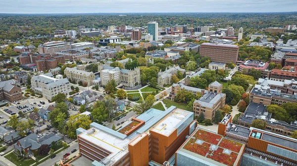 Michigan Üniversitesi kampüsünün havadan görünüşü, tarihi ve modern mimari karışımı, Ann Arbor şehir manzarasına yerleşmiş, yeşil girişimler sergiliyor.