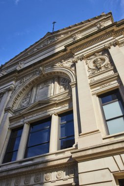 Fort Wayne, Indiana 'daki tarihi bir mahkeme binasının neoklasik mimarisi açık mavi gökyüzünün altında süslü detaylar sergiliyor.