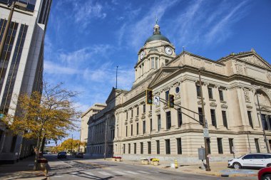 Fort Wayne, Indiana 'da saat kulesi olan Majestic Beaux-Arts adliyesi, açık mavi gökyüzüne karşı hukuk ve yönetimi temsil ediyor.