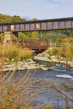 Modern bir köprü üzerindeki eski demiryolu kuleleri huzurlu doğa koruma alanı, Ann Arbor, Michigan, doğa ve insan yapımı yapılar arasındaki uyumu sembolize ediyor..