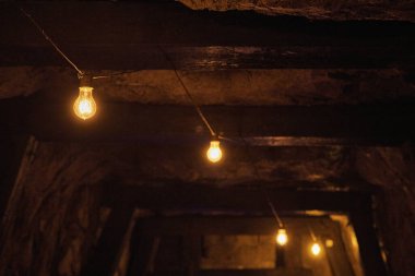 Bahama tarzı bir kafede taştan bir tavandan sarkan parlak parlak ampuller sıcak ve nostaljik bir atmosferi aydınlatıyor.