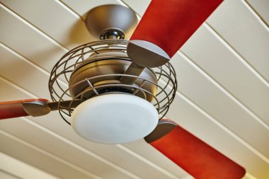 2015 'te Auburn, Indiana' da şık bir evde kırmızı maun bıçaklı ve buzlu cam ışıklı modern tavan vantilatörü.