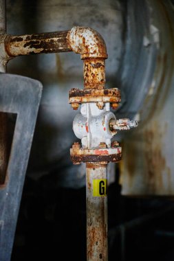 Terk edilmiş bir Ohio otelinde paslanmış, ihmal edilmiş bir endüstriyel vananın yakın çekimi çürümeyi ve zamanın akışını simgeliyor.