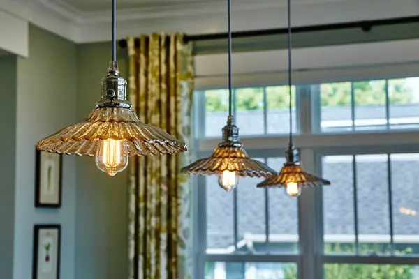 Elegant vintage pendant lights casting warm glow in a sophisticated interior space in Warsaw, Indiana, showcasing 2015s home design trends.
